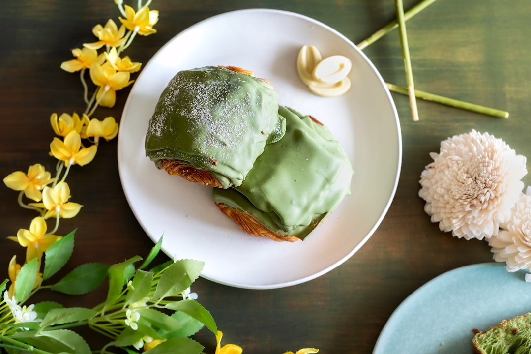 a-white-plate-topped-with-a-piece-of-cake-covered-in-green-frosting-aiaq9f6l2x8
